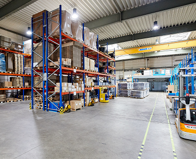 Organized industrial warehouse with high shelves and pallet storage / Organisiertes Industrie-Lager mit Hochregalen und Palettenlagerung